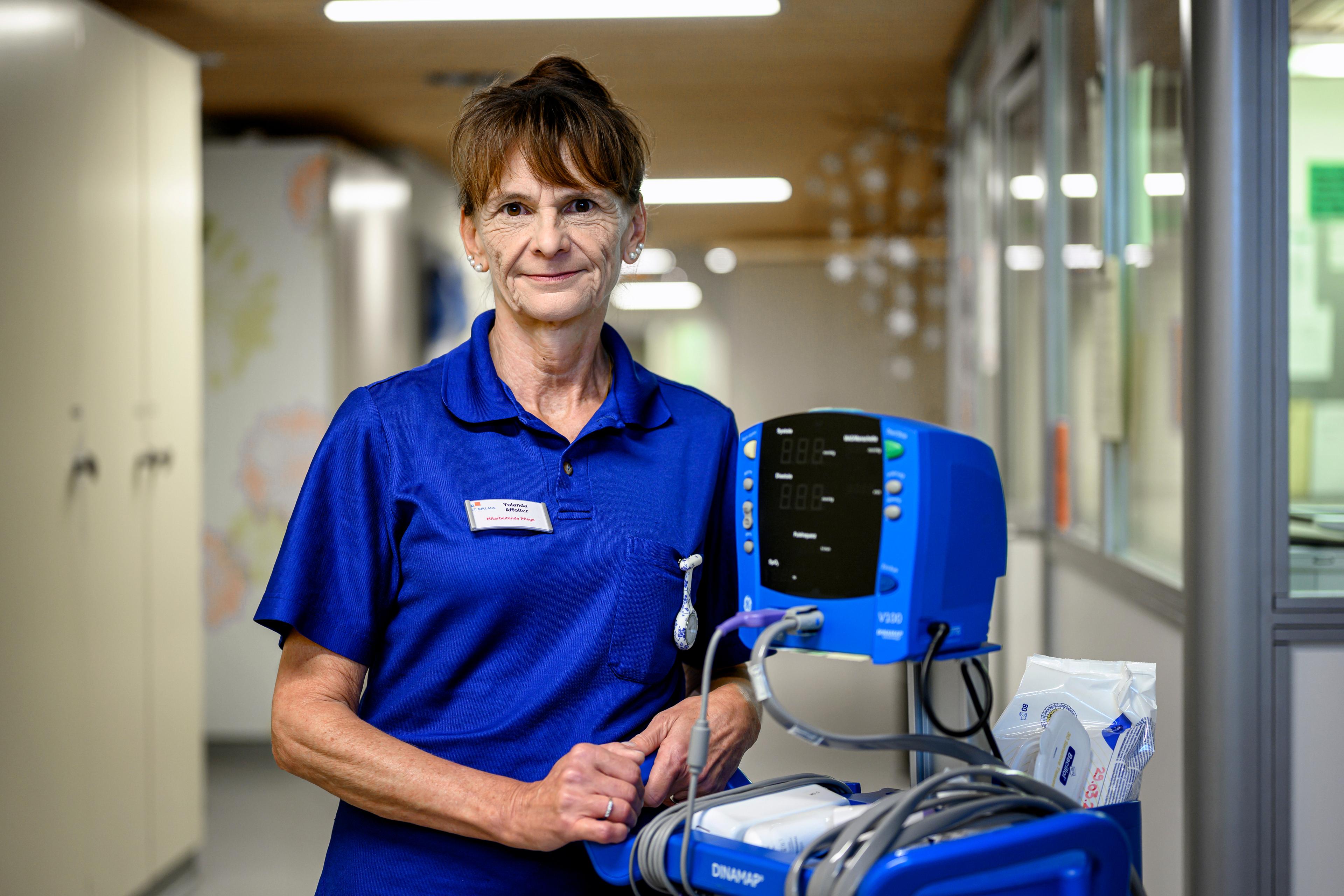 Foto ritratto dell'assistente infermieristica del CRS Yolanda Affolter. Accanto a lei un dispositivo per la misurazione della pressione sanguigna.