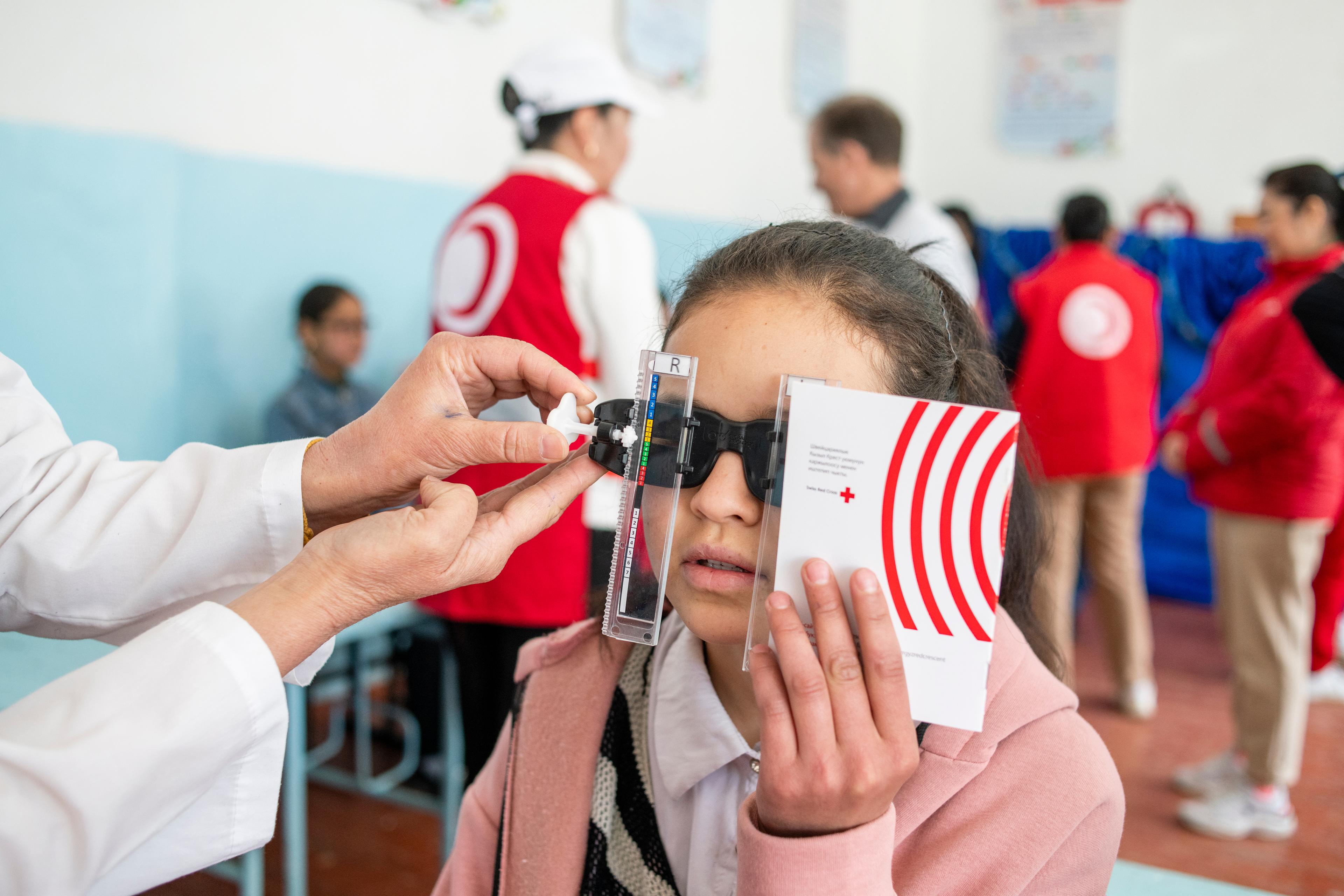 In einer Schule in Kirgistan wird die Augengesundheit eines Mädchens kontrolliert. 