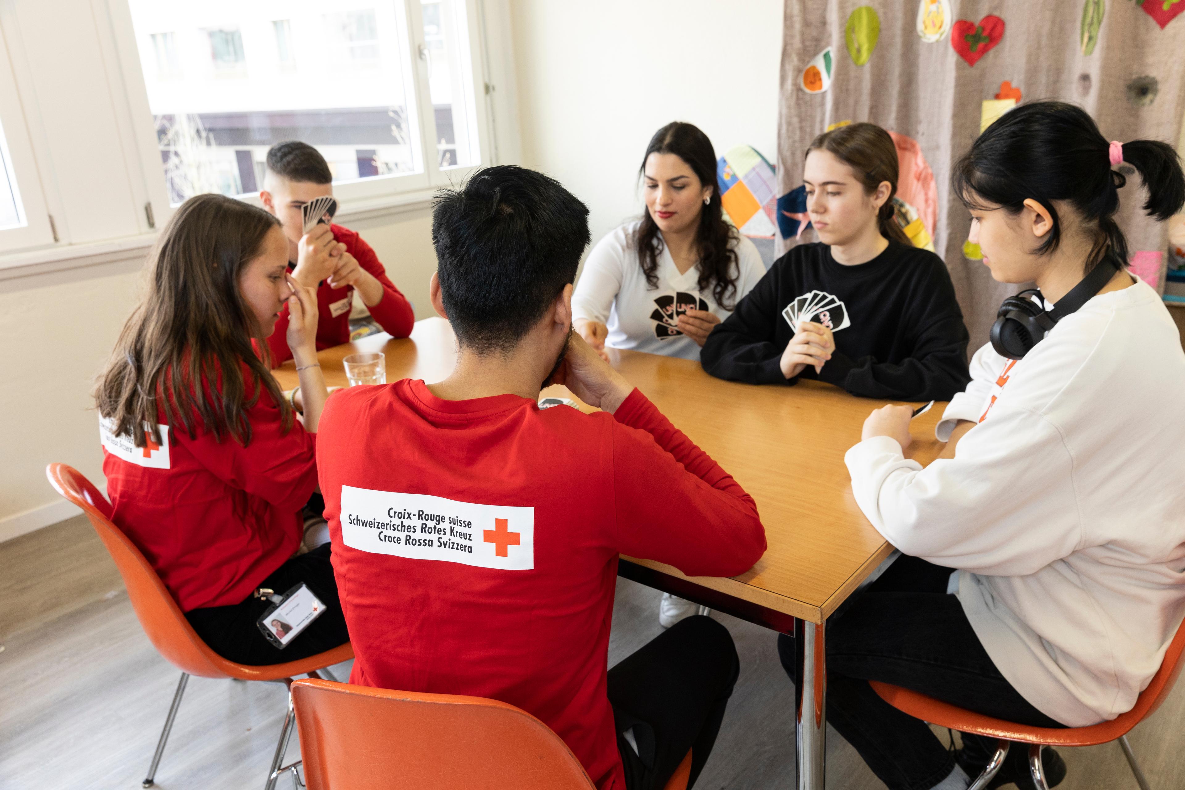 Progetto integrativo pomeridiano della Croce Rossa Gioventù di Lucerna. I partecipanti giocano a carte con tre volontari della Croce Rossa Gioventù di Lucerna. Nella foto Roshan-Ali Akhondzadeh (al centro, di spalle, con la maglietta rossa), Muriel Elmiger e Yassien El Hassamy, Mariam Aaouine, Marina Plesca e Fatemeh Hosseini.