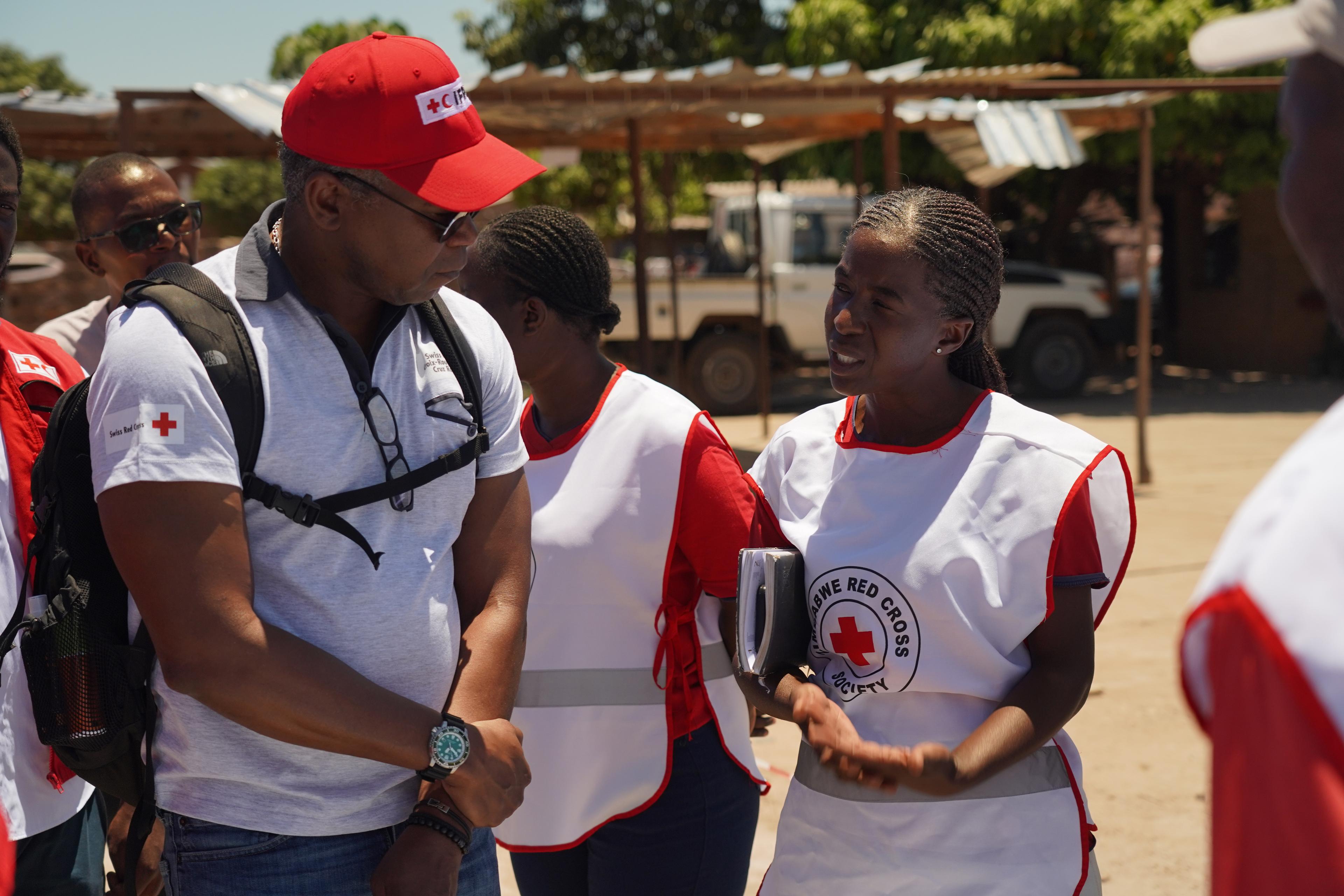Agenor Junior Clerge, responsabile per le emergenze sanitarie presso la CRS, parla con una collega della Croce Rossa dello Zimbabwe.