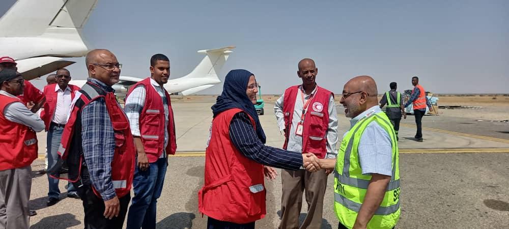 La Secrétaire générale du Croissant-Rouge soudanais entourée de collaborateurs à l’aéroport de Port-Soudan. Elle reçoit l’aide de la Fédération internationale.