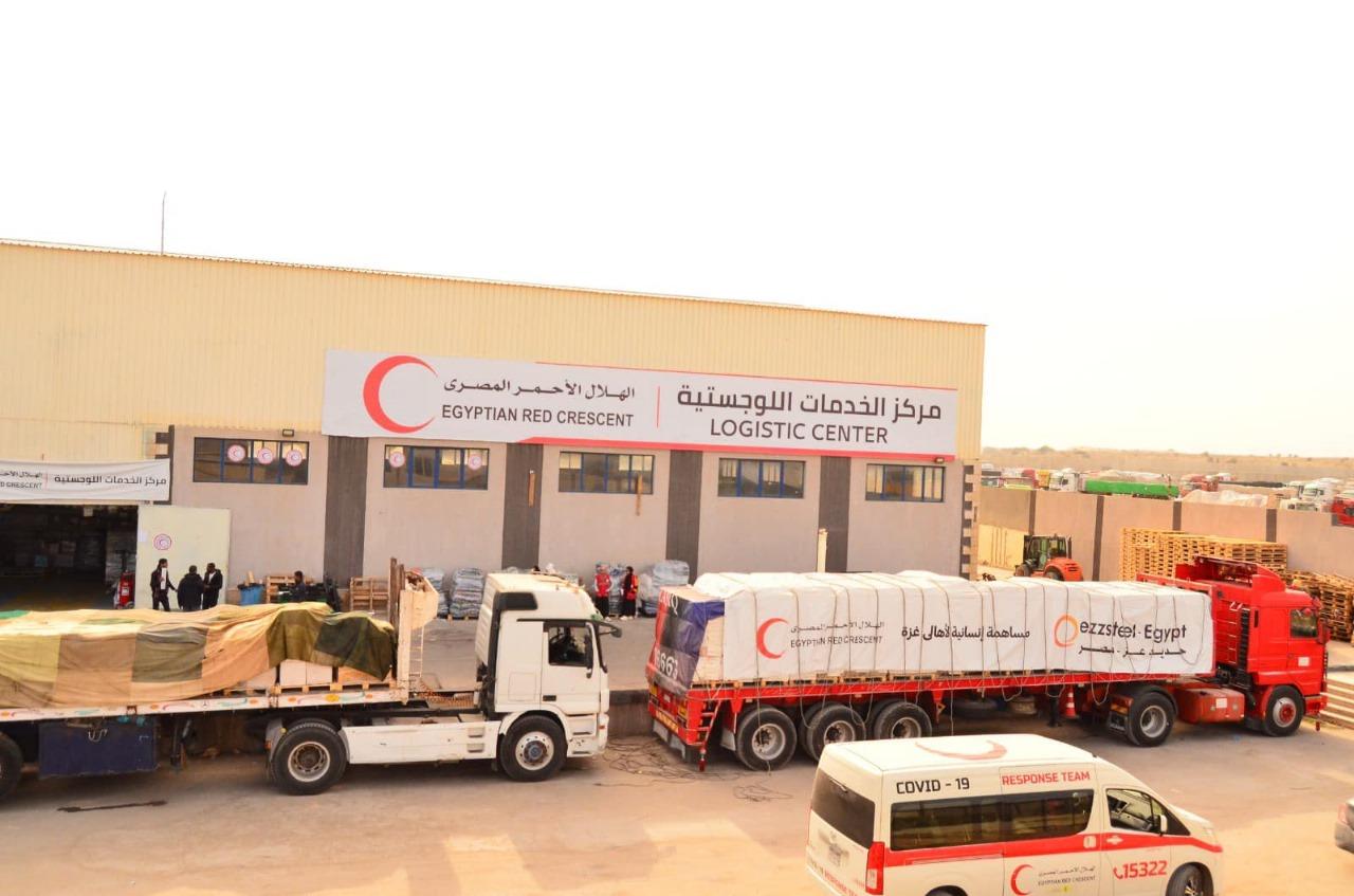 Deux camions sont chargés de matériel de secours pour Gaza au centre logistique du Croissant-Rouge égyptien.
