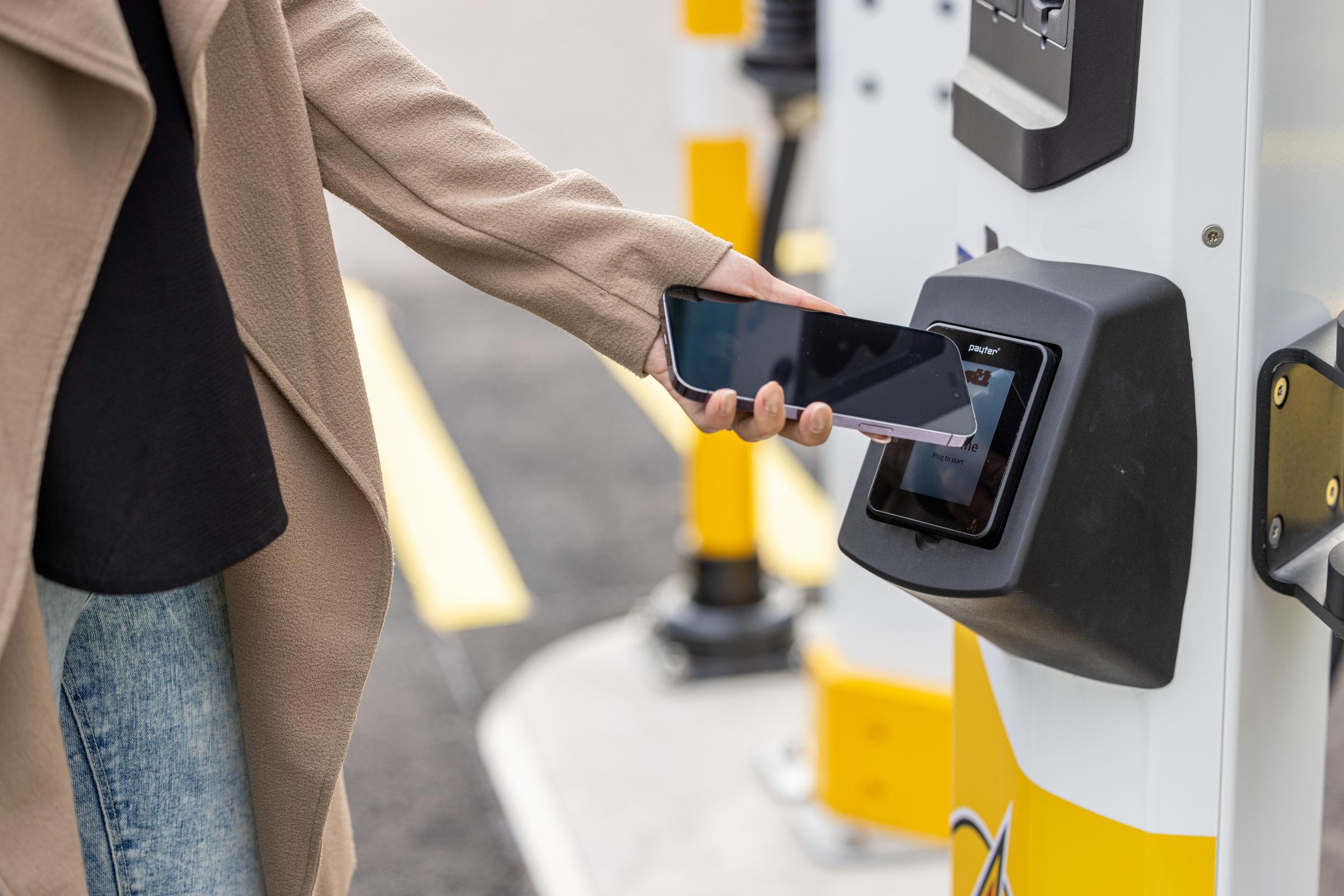 Nainen maksamassa latausta puhelimen lähimaksulla