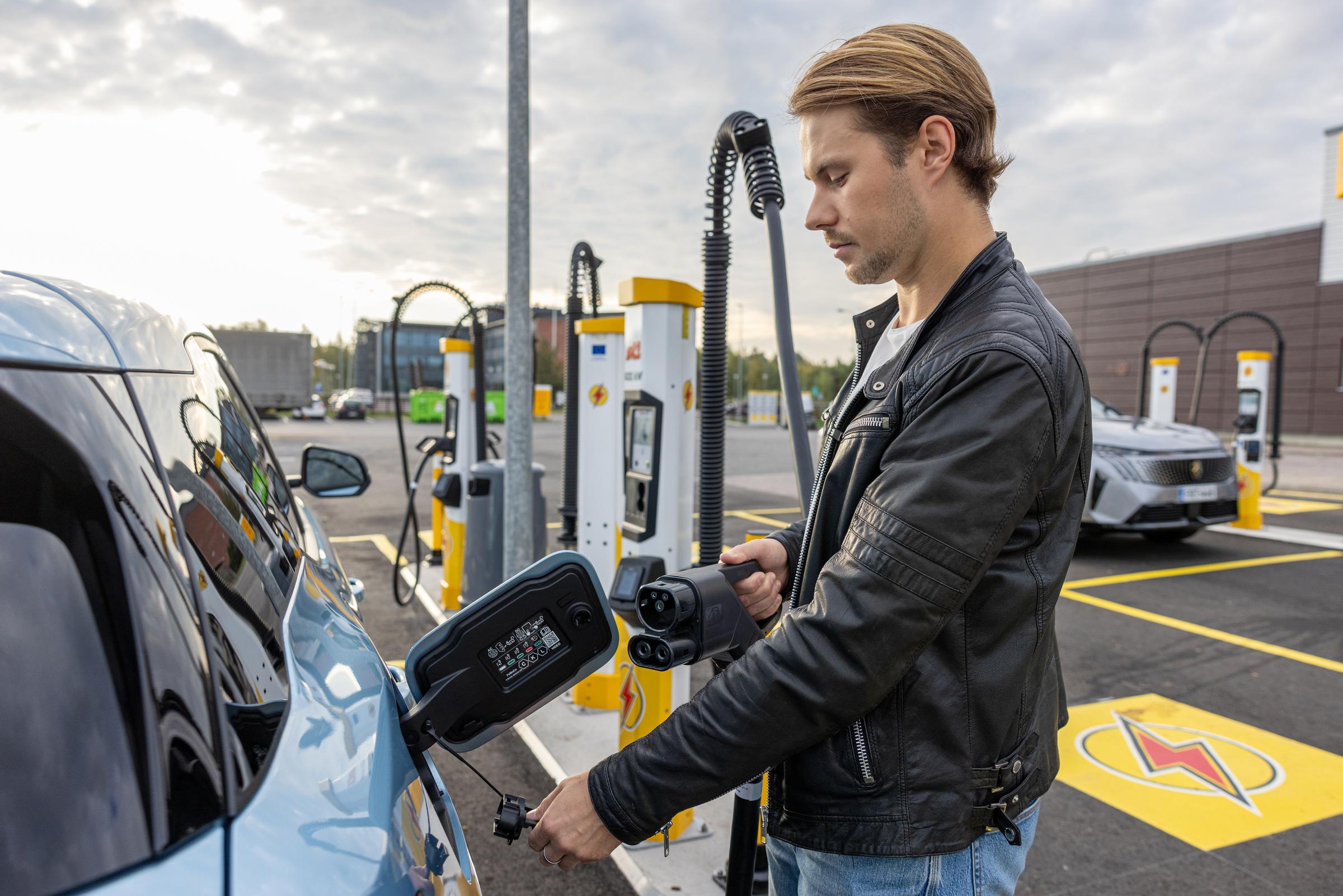 Man som laddar ett elfordon