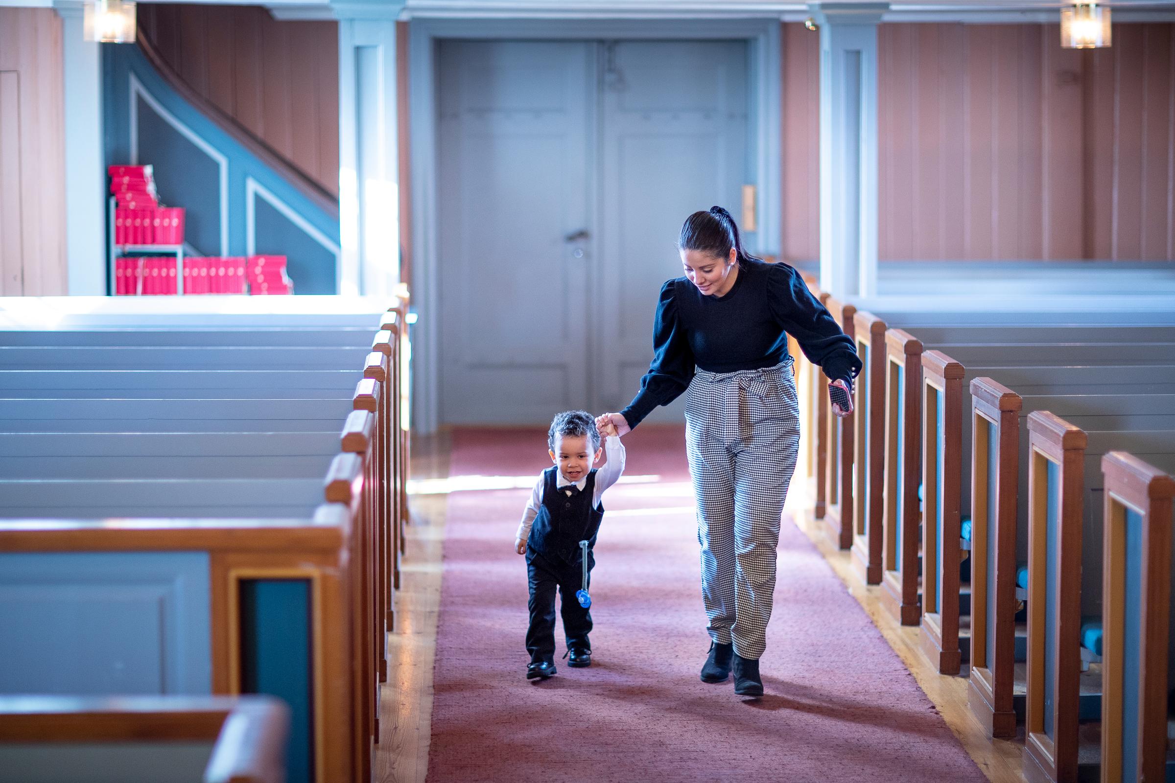 Mor og barn går ned kirkegulvet